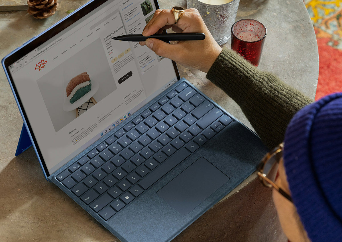 Hand with stylus on tablet viewing product 'The Keep it Cozy Sweater' on SUPER SHOPPING NOW! — 'ADD TO CART' 'Reviews'