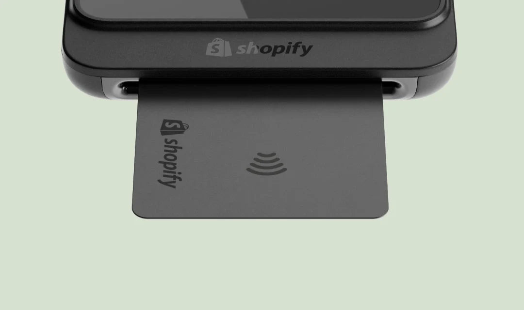 Card reader and Shopify-branded payment card showing 'shopify' and a contactless payment symbol